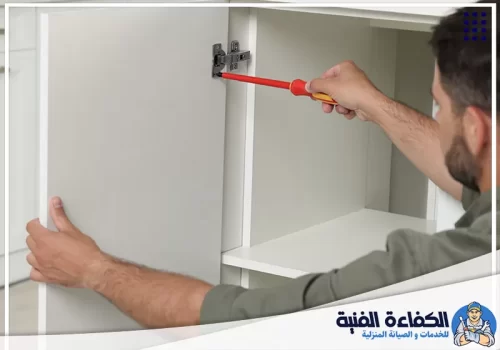 أسعار صيانة مطابخ في الفجيرة وراس الخيمة فني شركة صيانة مطابخ في الفجيرة ورأس الخيمة أثناء إصلاح دواليب المطبخ وتحسين الإغلاق