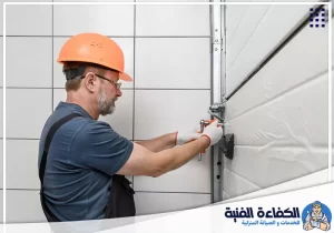 ضبط مسار باب الكراج والمفصلات بواسطة فني تصليح أبواب الكراجات في رأس الخيمة لتحسين الحركة.